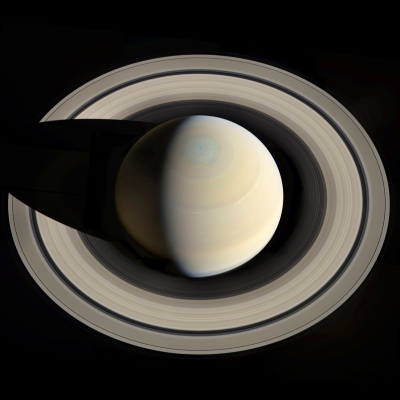 Saturn, a pale yellow-brown planet surrounded by prominent icy rings.